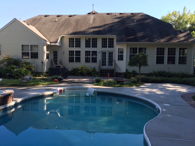 A large pool in front of a house.